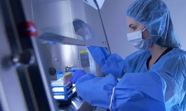 Medical professional preparing bone marrow concentrate in a lab setting.