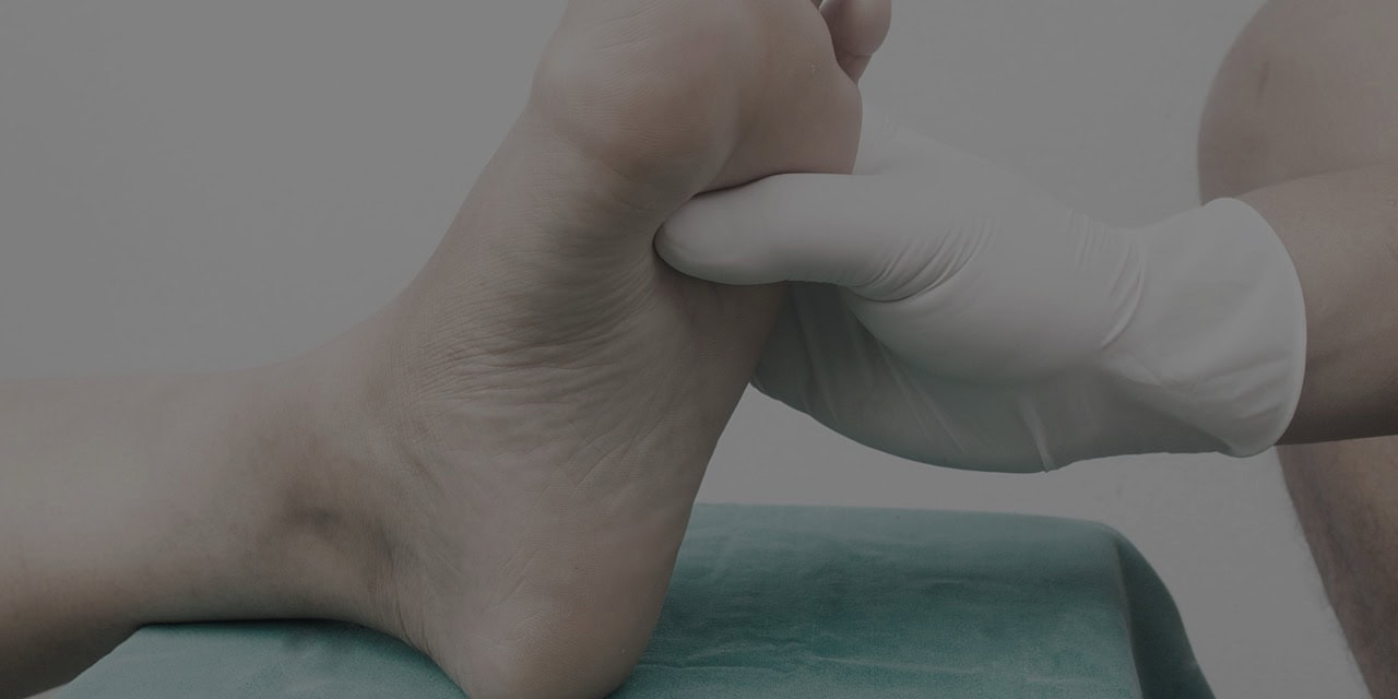 Podiatrist examining a patient's foot for pain or injury.