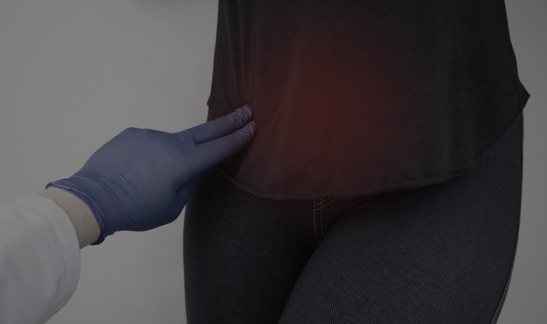 Healthcare professional wearing gloves examining a patient's abdomen.