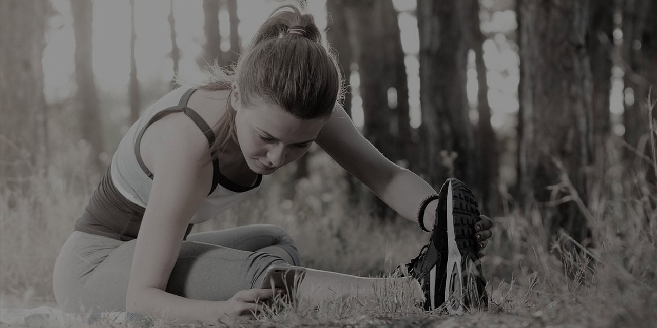 Woman stretching outdoors for pain relief at Northwest Suburban Pain Center.