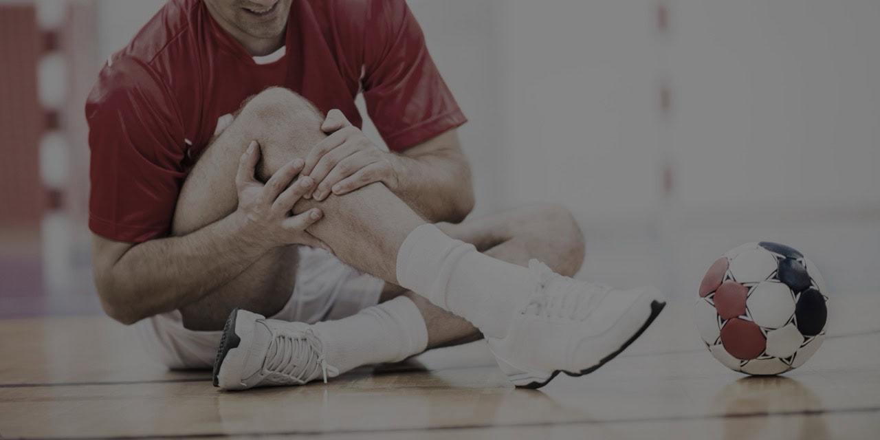 Physical therapist providing knee pain treatment to young athlete.